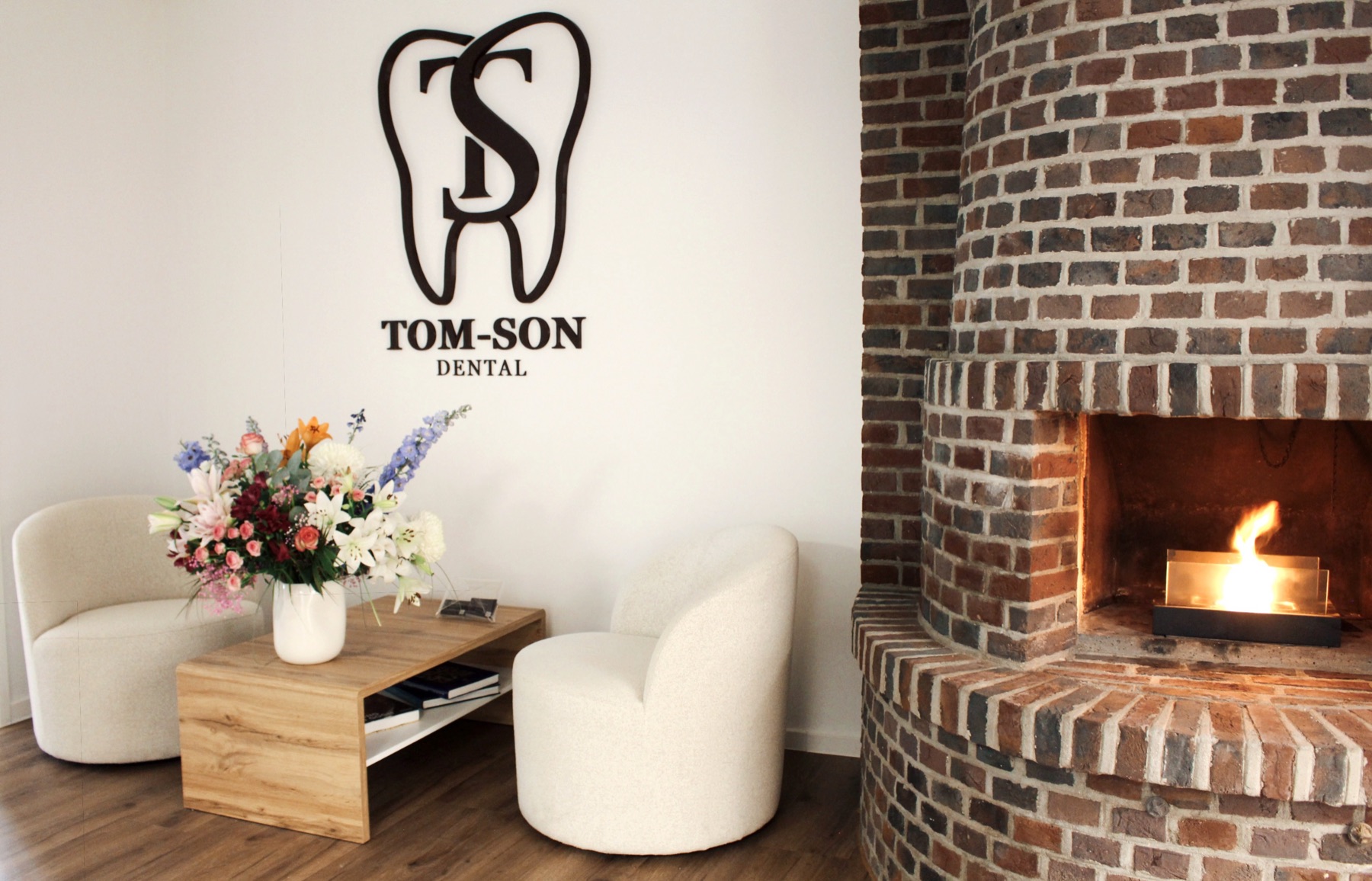 Lounge von Tom-Son Dental mit Kamin und Sitzecke